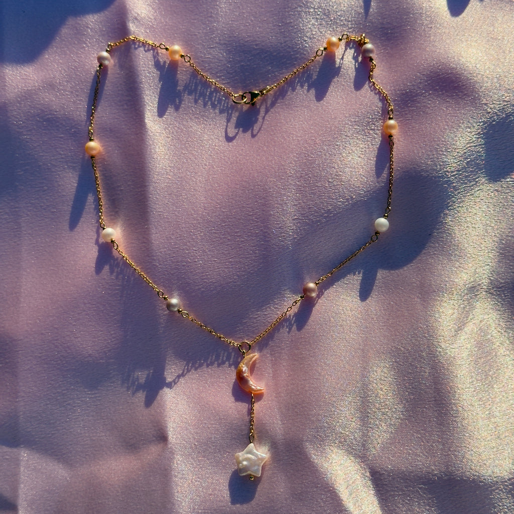 Necklace with pink and white beads on a textured purple fabric background