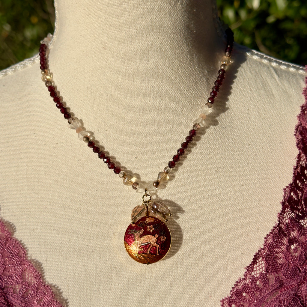 Necklace with a pendant featuring a deer design on a mannequin bust.