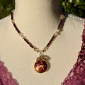 Necklace with a pendant featuring a deer design on a mannequin bust.