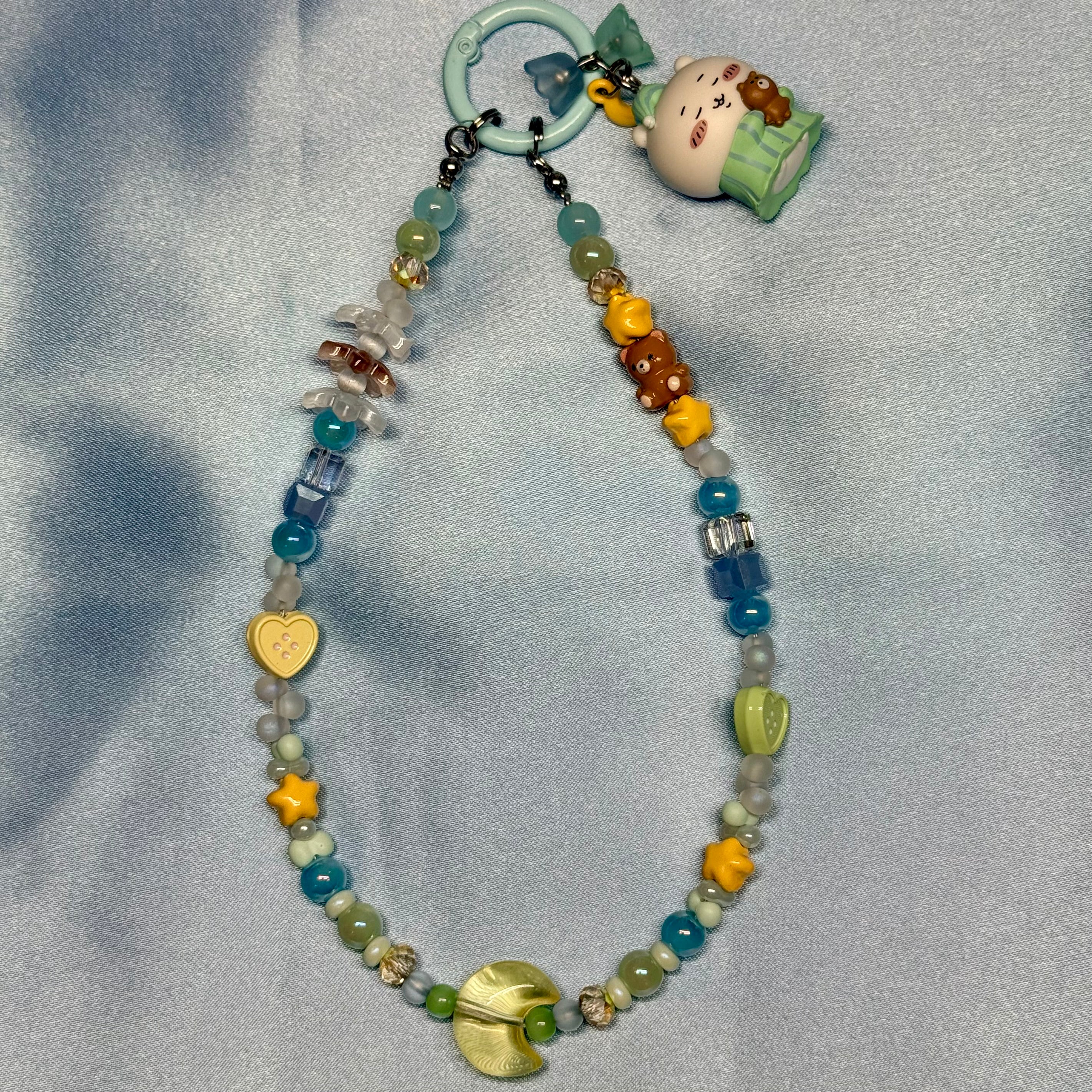 Beaded keychain with a small figurine on a gray background