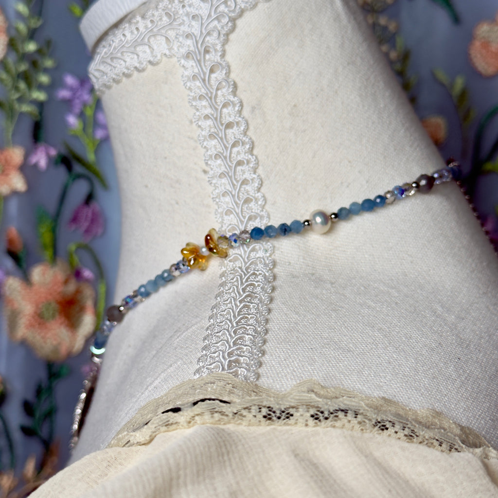 Close-up of a decorative necklace on a mannequin with floral background