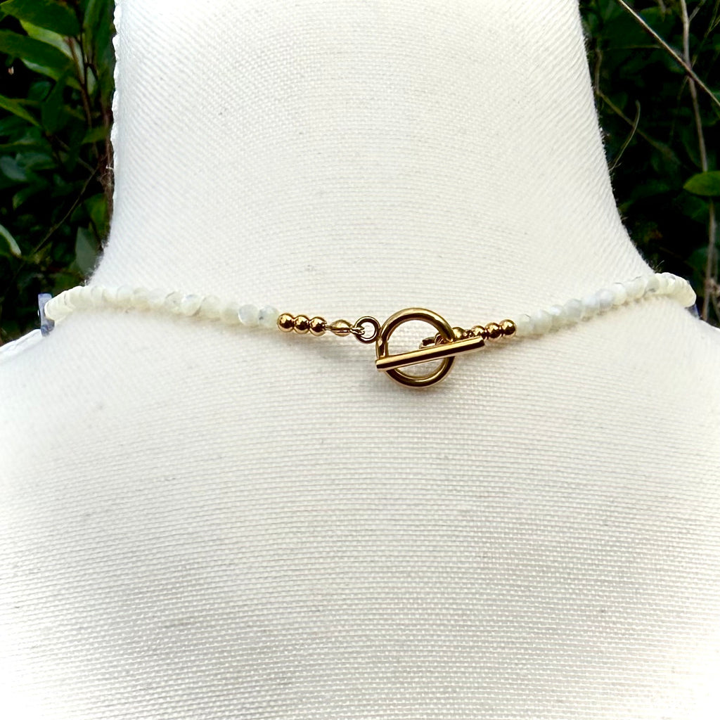 Necklace with a toggle clasp on a mannequin bust against a natural background