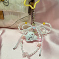 Cute cat-shaped phone charm with beads on a pink background
