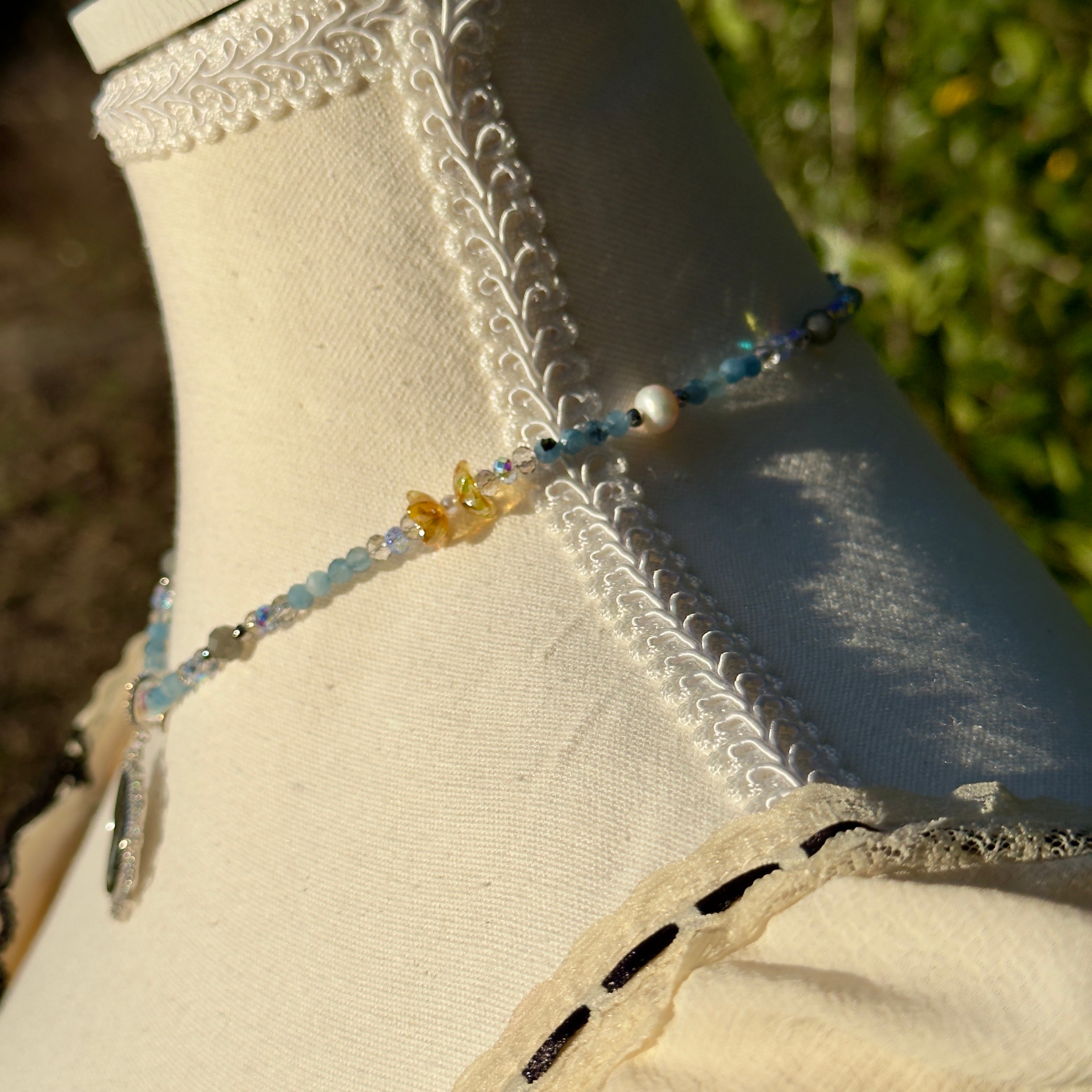 Beaded necklace on a mannequin with a blurred natural background