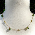 Necklace with green beads on a white mannequin