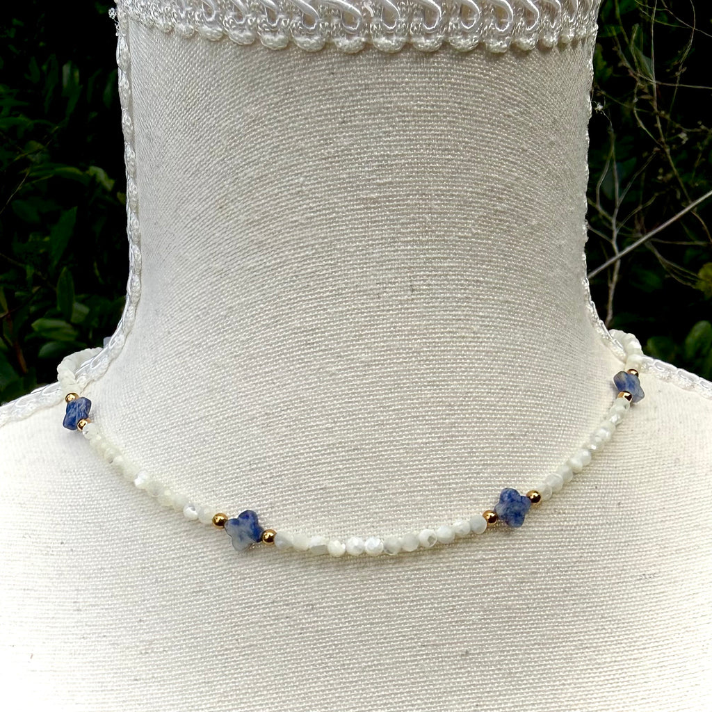 Crystal  necklace with blue beads on a mannequin against a natural background