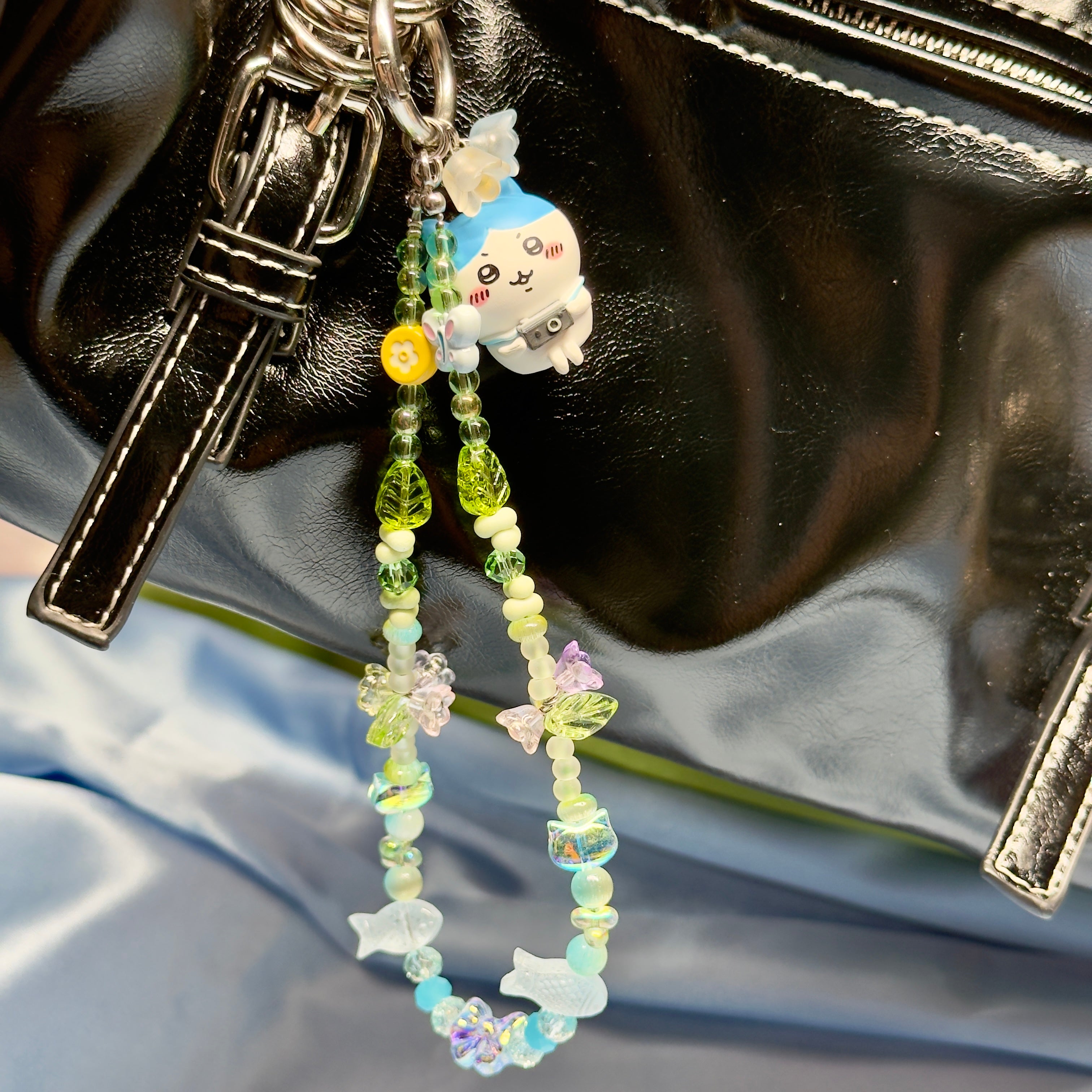 Keychain with beads and a small figurine on a black surface