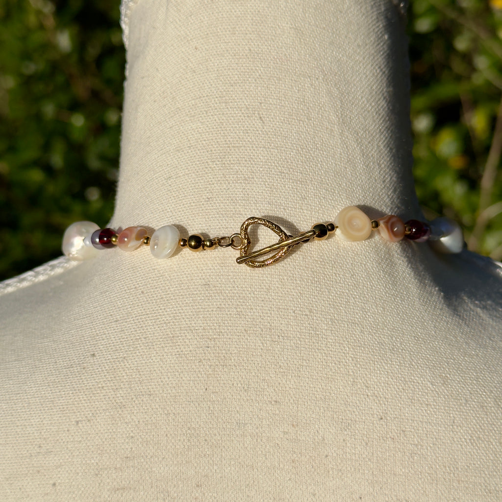 Back of Beaded necklace with a gold hook on a mannequin against a natural background