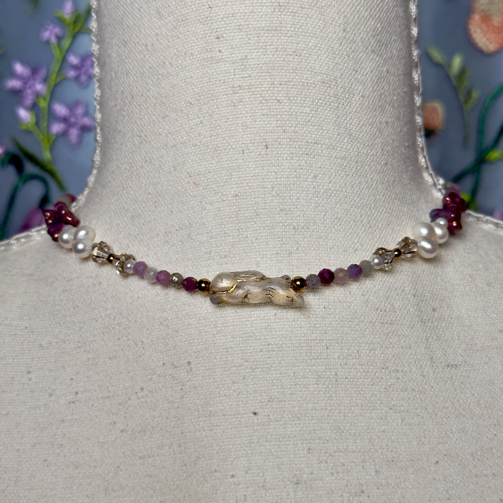 Necklace with beads on a mannequin bust against a floral background
